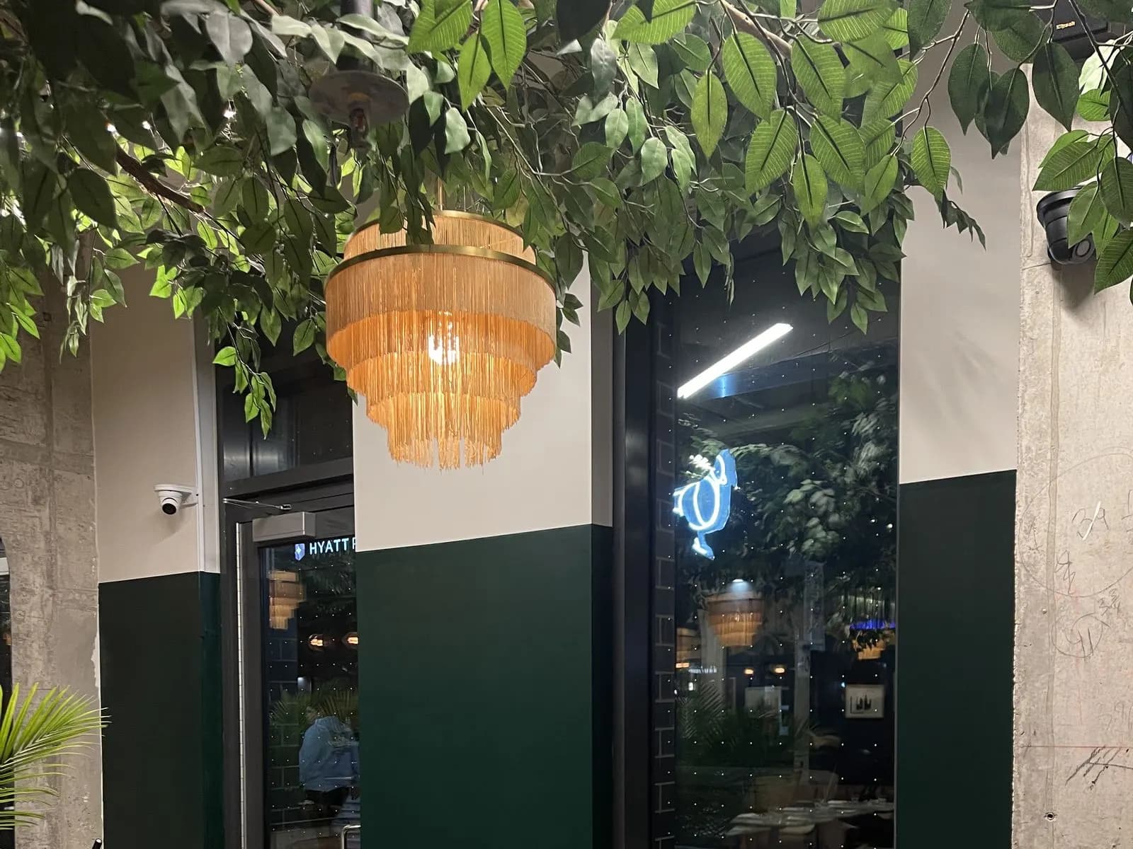 Deep green café wall with warm leather seating and framed art